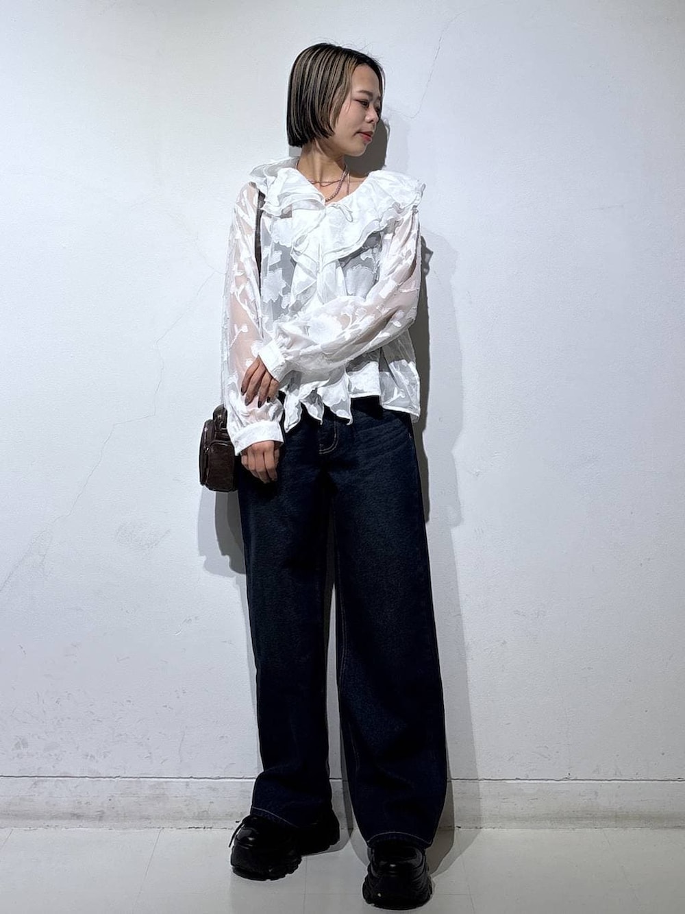 ブラック系のスニーカー、ブラック系のキャミソール、ブルー系のスラックスを着用したレディースの春コーディネートの2枚目の写真