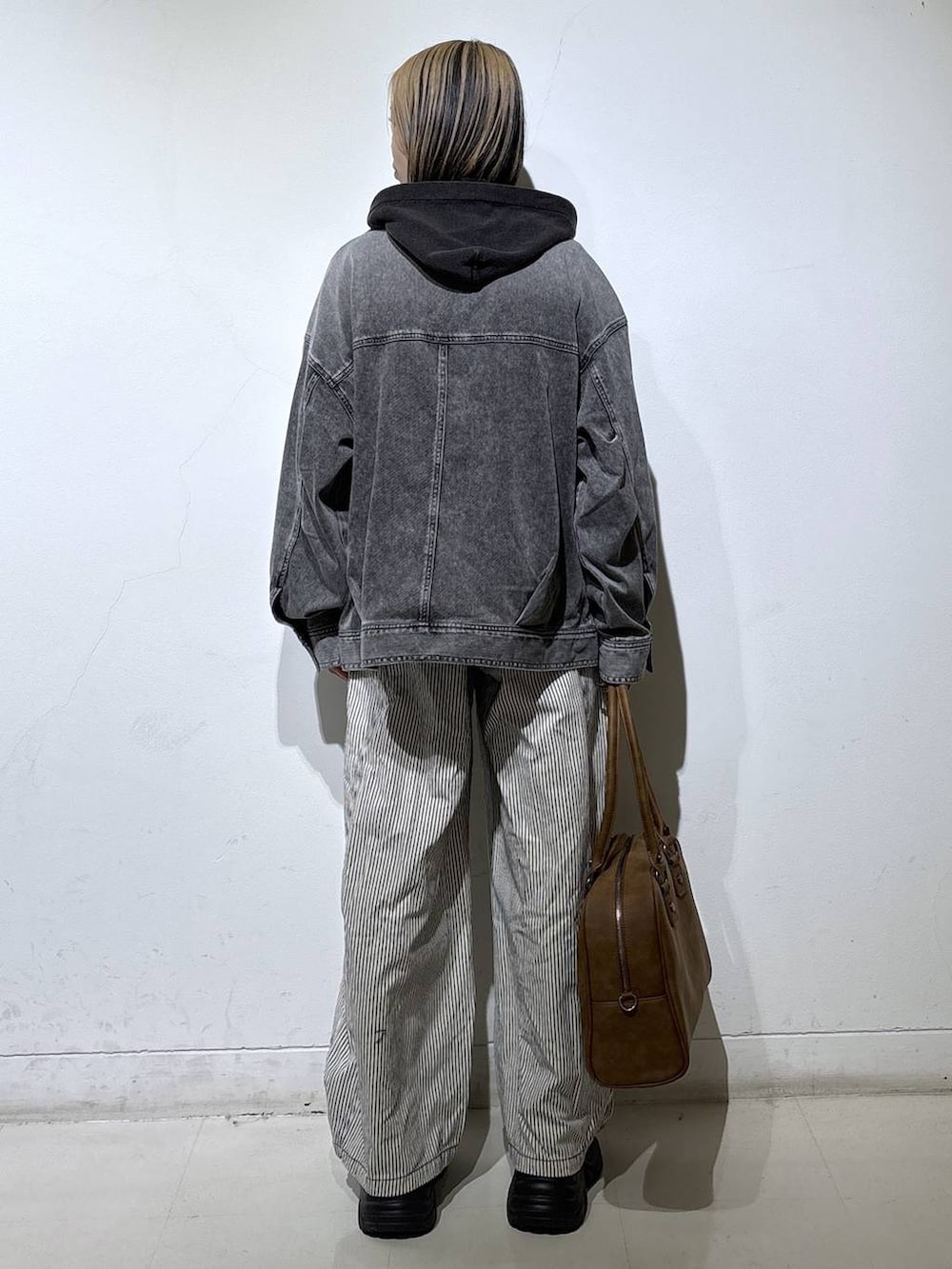 ブラック系のブーツ、ベージュ系のボストンバッグ、ブラック系のTシャツ/カットソーを着用したレディースの冬コーディネートの5枚目の写真