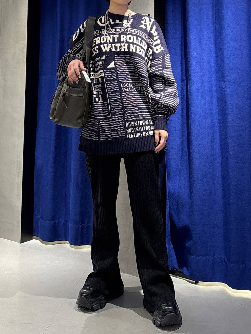 ブラック系のブーツ、グリーン系のボストンバッグ、ブラック系のその他パンツを着用したレディースの冬コーディネートの2枚目の写真