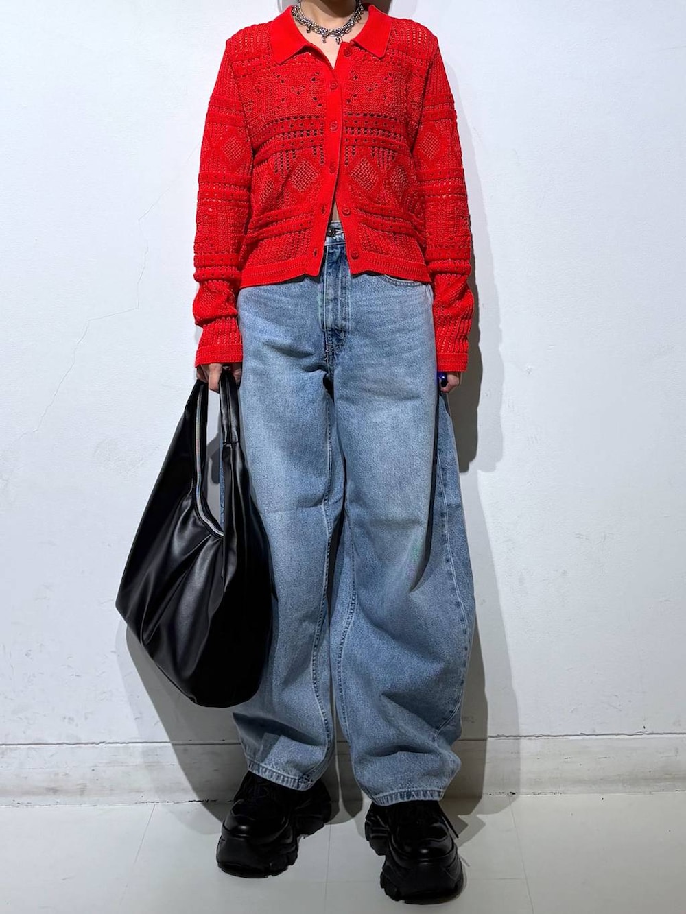 ブラック系のスニーカー、ブラック系のキャミソール、ブルー系のデニムパンツを着用したレディースの春コーディネートの3枚目の写真