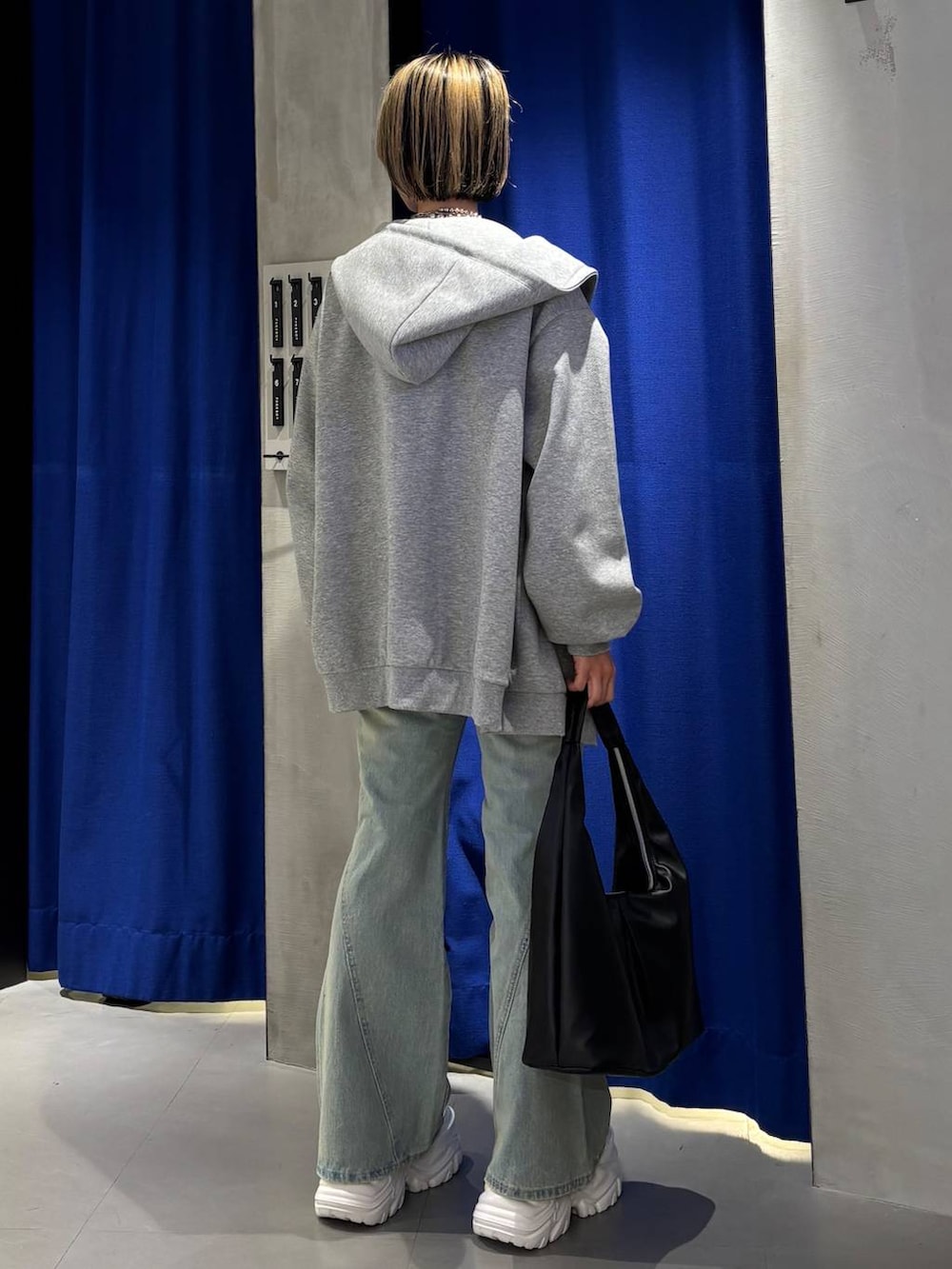 ホワイト系のスニーカー、ブラック系のキャミソール、ブルー系のデニムパンツを着用したレディースの春コーディネートの4枚目の写真