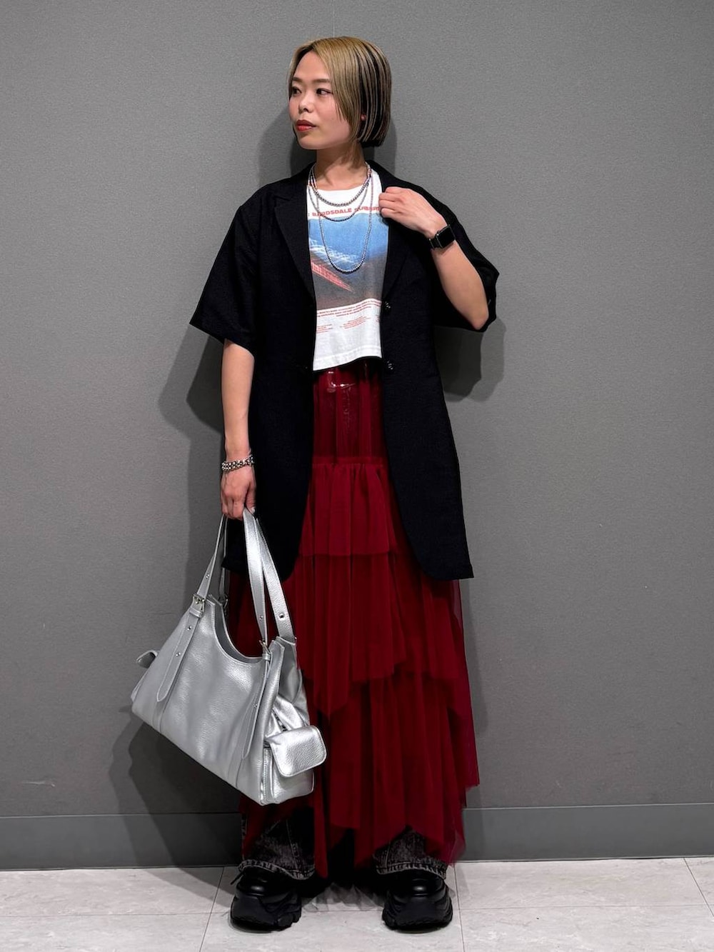 ブラック系のスニーカー、ブラック系のデニムパンツ、ホワイト系のTシャツ/カットソーを着用したレディースの春コーディネートの2枚目の写真