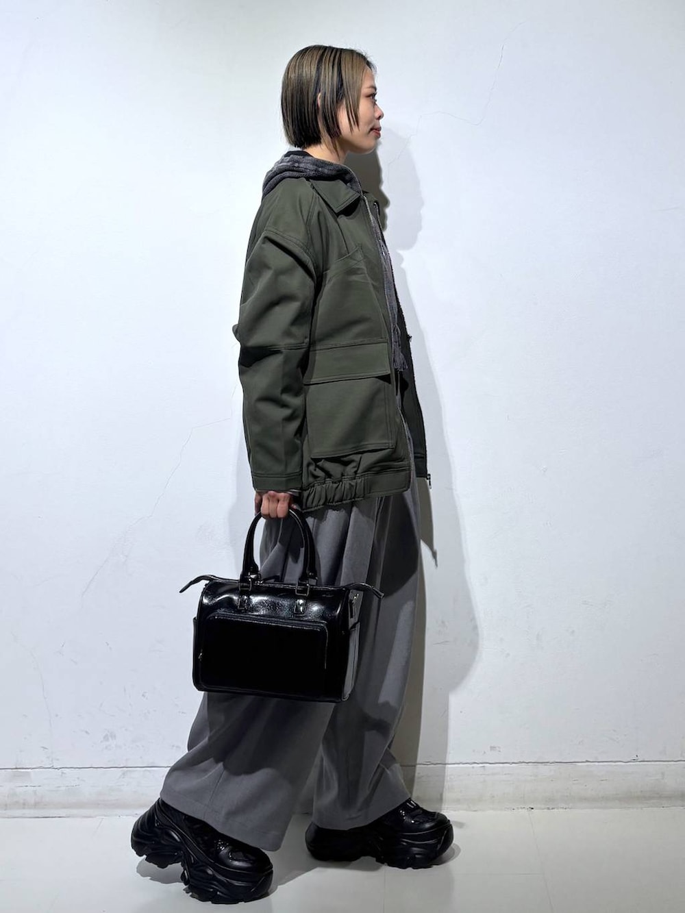 ブラック系のスニーカー、グレー系のパーカー、ブラック系のショルダーバッグを着用したレディースの春コーディネートの4枚目の写真