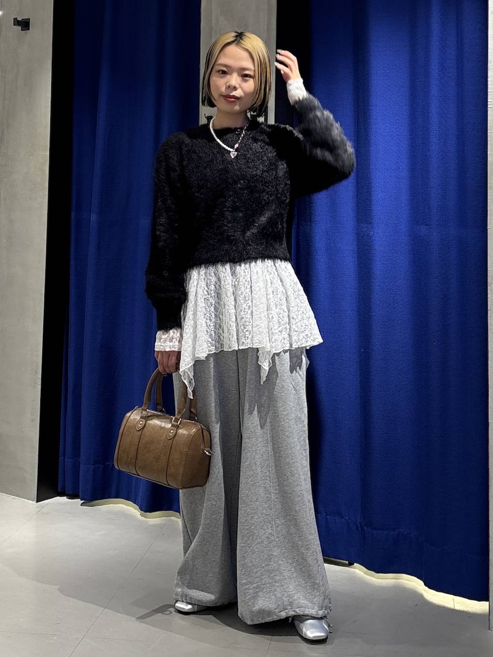 ブラウン系のボストンバッグ、グレー系のスウェットパンツ、シルバー系のスニーカーを着用したレディースの冬コーディネートの4枚目の写真