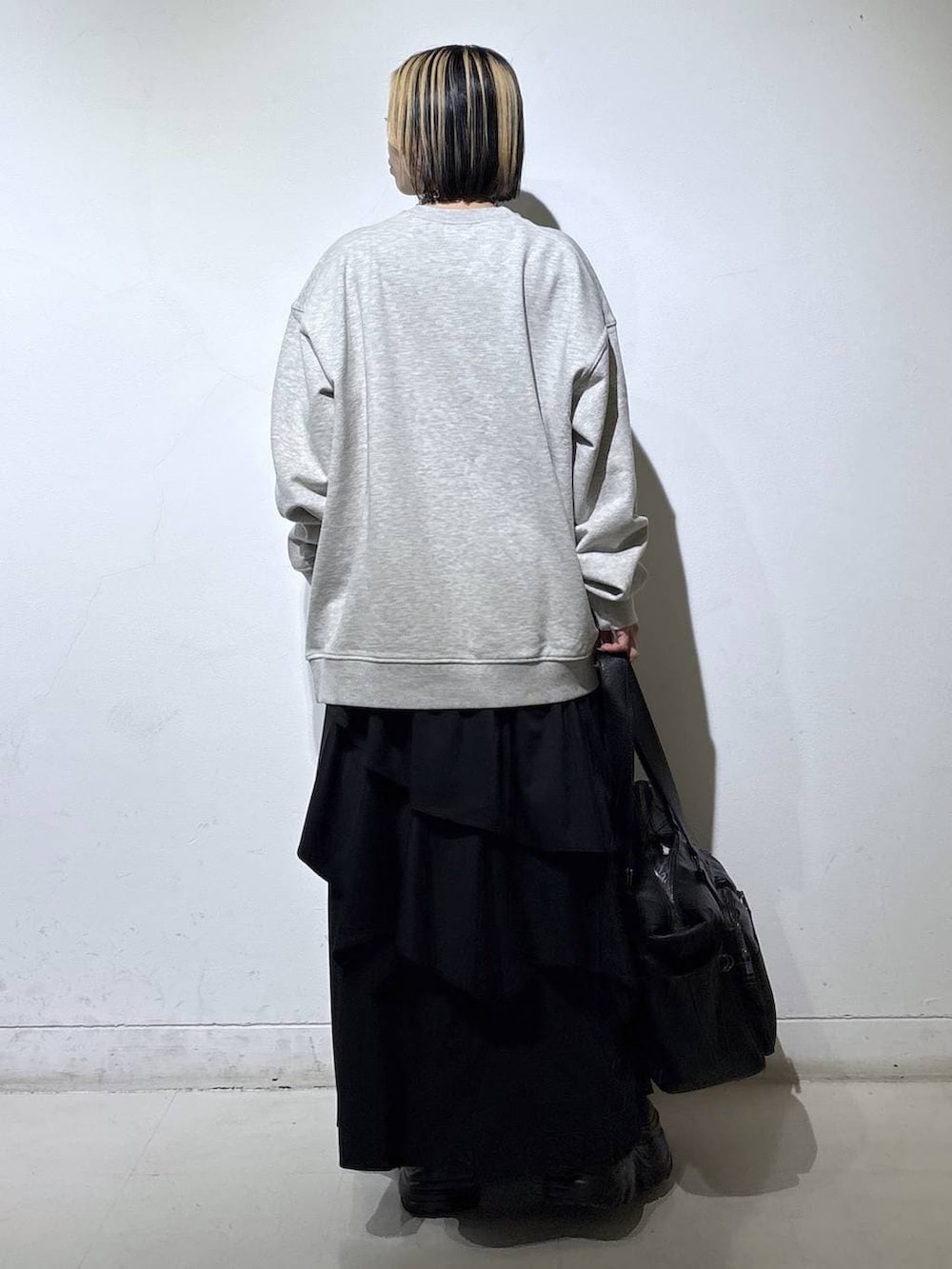 ブラウン系のブーツ、ブラック系のボストンバッグ、ブラック系のスカートを着用したレディースの冬コーディネートの4枚目の写真