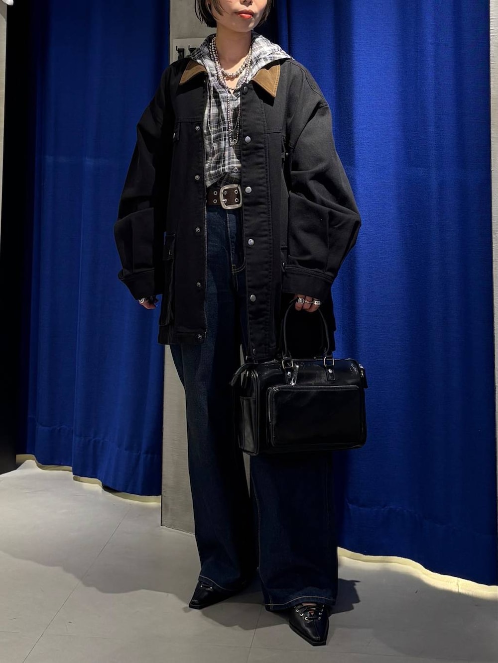ブルー系のデニムパンツ、ブラック系のショルダーバッグ、ブラック系のサンダルを着用したレディースの春コーディネートの2枚目の写真