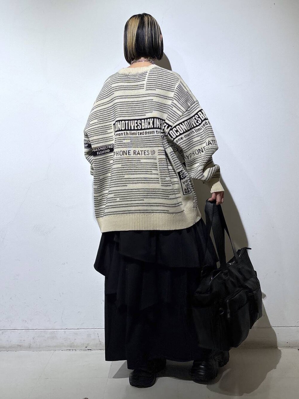 ブラウン系のブーツ、ブラック系のボストンバッグ、ブラック系のスカートを着用したレディースの冬コーディネートの4枚目の写真