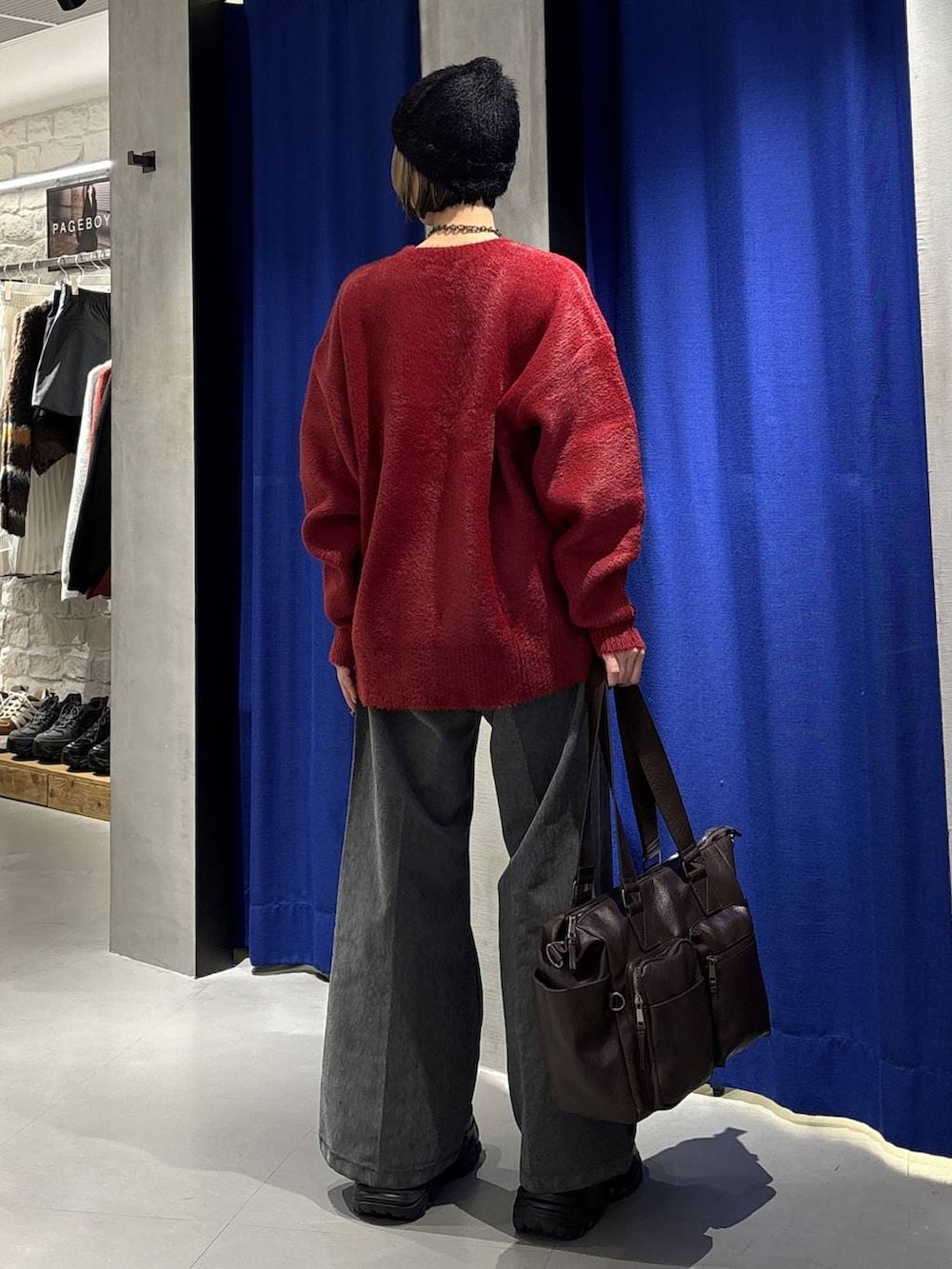 ブラック系のブーツ、ブラウン系のボストンバッグ、レッド系のニット/セーターを着用したレディースの冬コーディネートの4枚目の写真