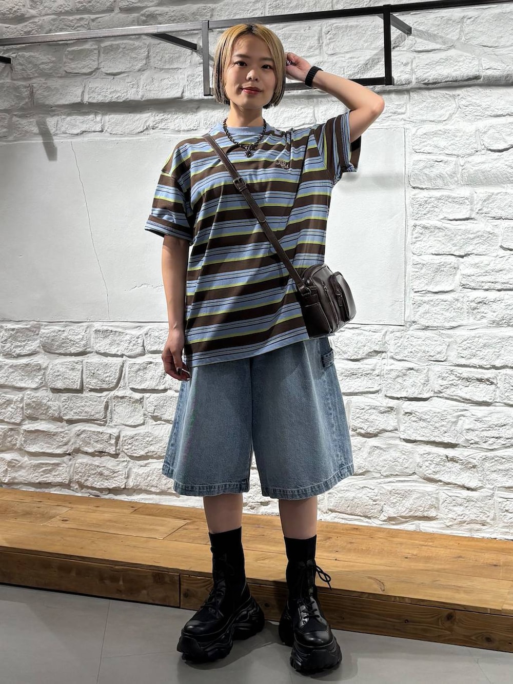 ブラック系のブーツ、ブラウン系のショルダーバッグ、ブラウン系のTシャツ/カットソーを着用したレディースの春コーディネートの2枚目の写真