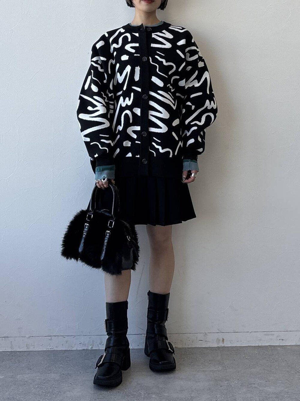 ブラック系のブーツ、ブラック系のボストンバッグ、ブラック系のその他パンツを着用したレディースの冬コーディネートの5枚目の写真