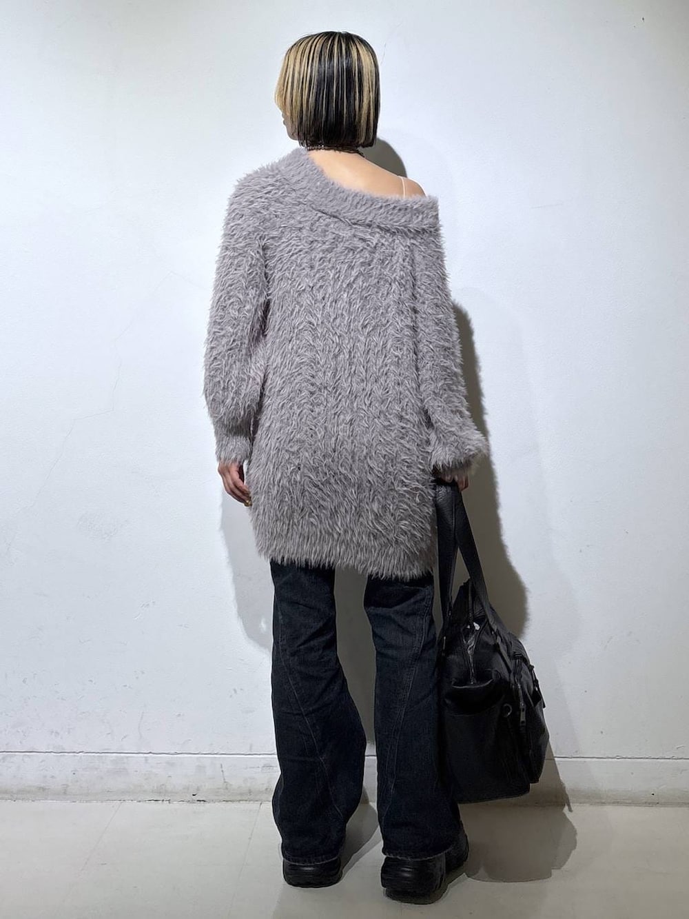 ブラウン系のブーツ、ブルー系のデニムパンツ、ブラック系のボストンバッグを着用したレディースの冬コーディネートの4枚目の写真