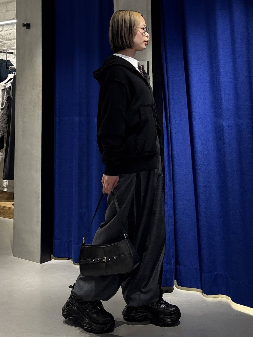 ブラック系のスニーカー、グレー系のその他パンツ、ホワイト系のシャツ/ブラウスを着用したレディースの春コーディネートの3枚目の写真