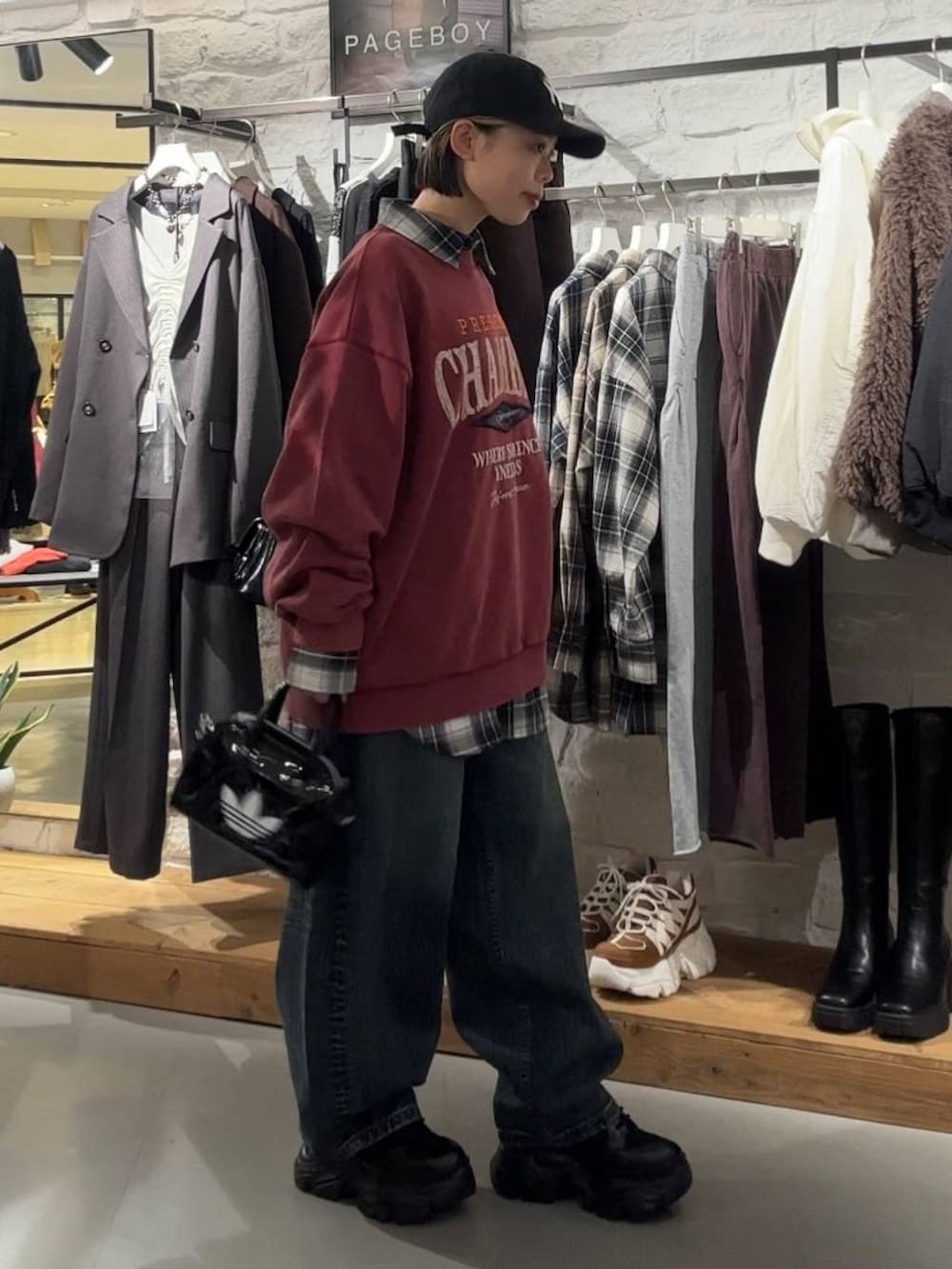 ブラック系のブーツ、レッド系のスウェット、ブラック系のTシャツ/カットソーを着用したレディースの秋コーディネートの4枚目の写真