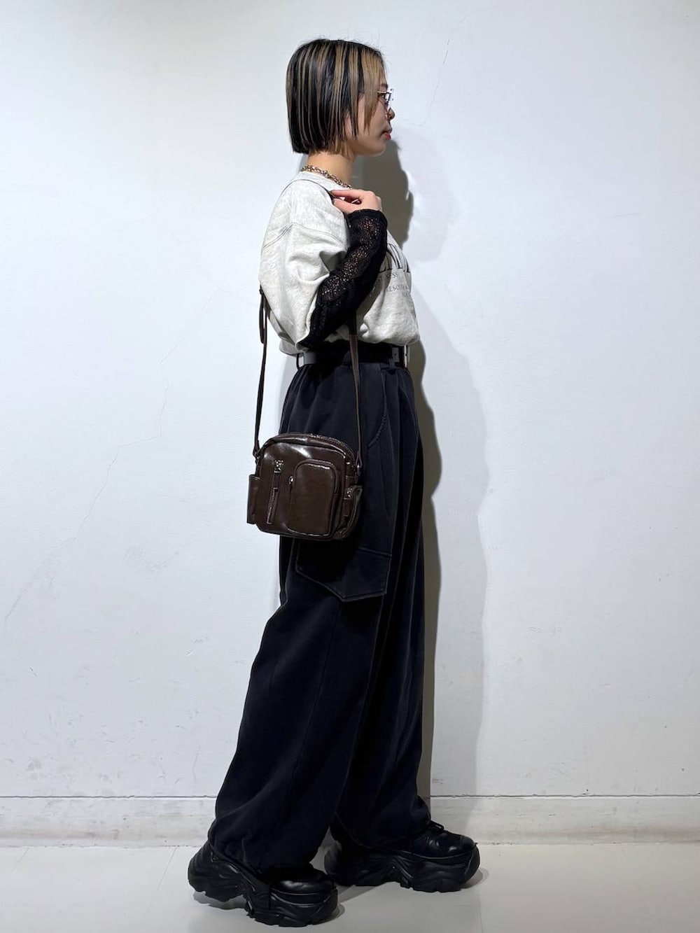 ブラック系のスニーカー、ブラウン系のショルダーバッグ、ブラック系のTシャツ/カットソーを着用したレディースの春コーディネートの4枚目の写真