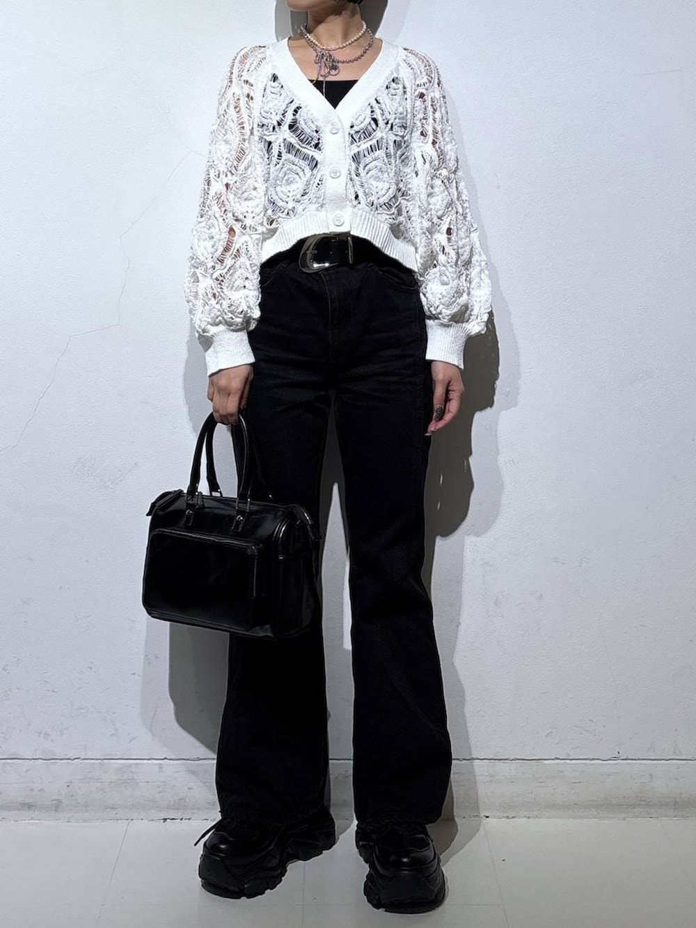 ブラック系のスニーカー、ブラック系のキャミソール、ホワイト系のカーディガン/ボレロを着用したレディースの春コーディネートの2枚目の写真