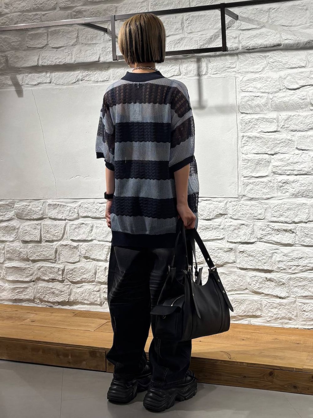 ブラック系のスニーカー、ブラック系のハンドバッグ、ブラック系のデニムパンツを着用したレディースの夏コーディネートの5枚目の写真