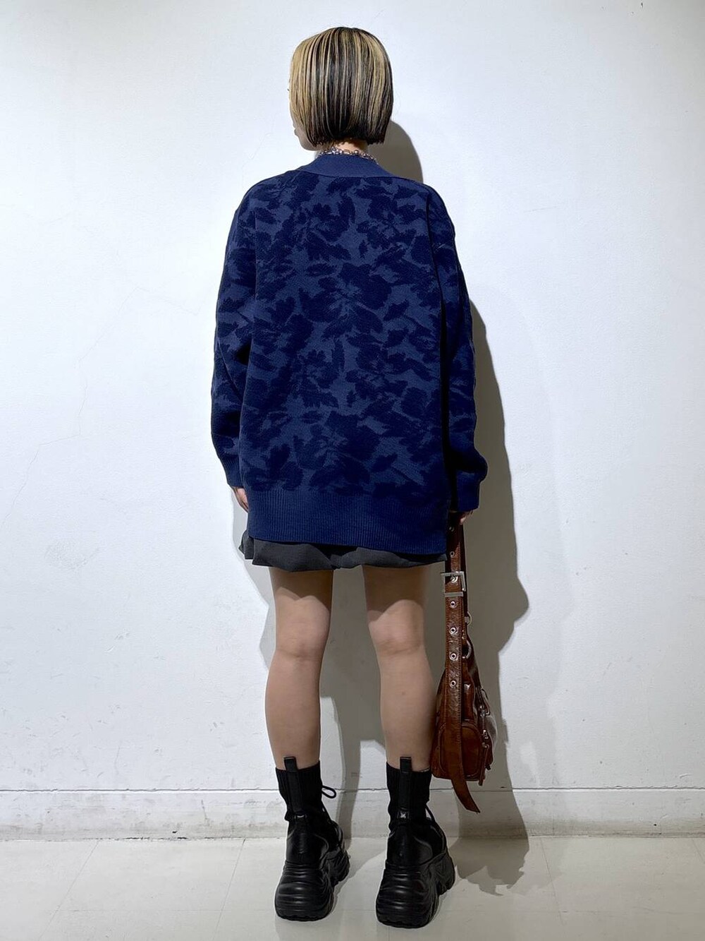 ブラック系のブーツ、ホワイト系のTシャツ/カットソー、ブラウン系のショルダーバッグを着用したレディースの秋コーディネートの4枚目の写真