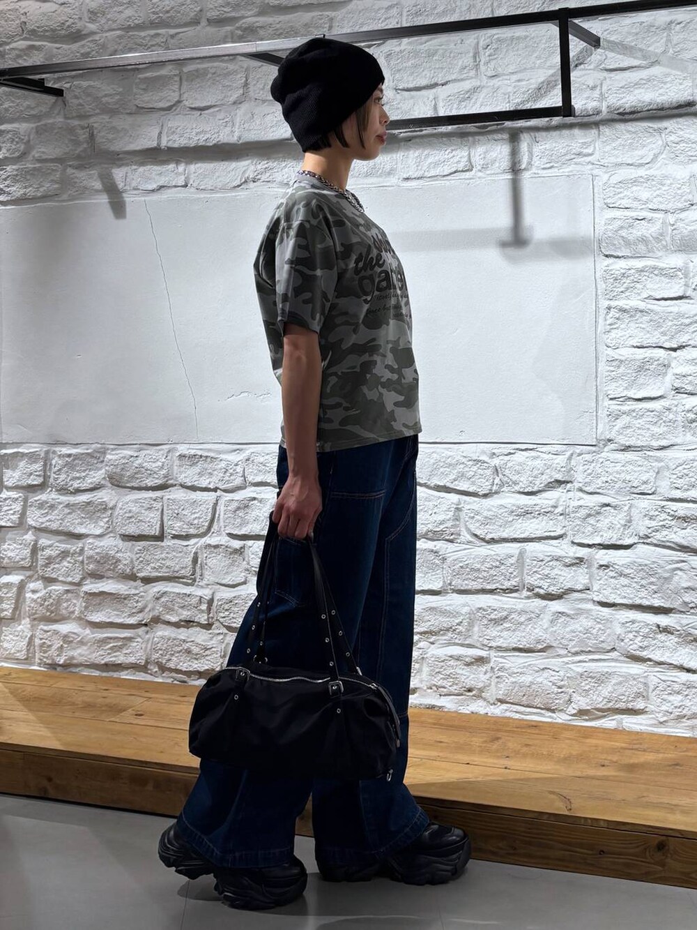 ブラック系のスニーカー、ブルー系のデニムパンツ、その他のTシャツ/カットソーを着用したレディースの春コーディネートの4枚目の写真