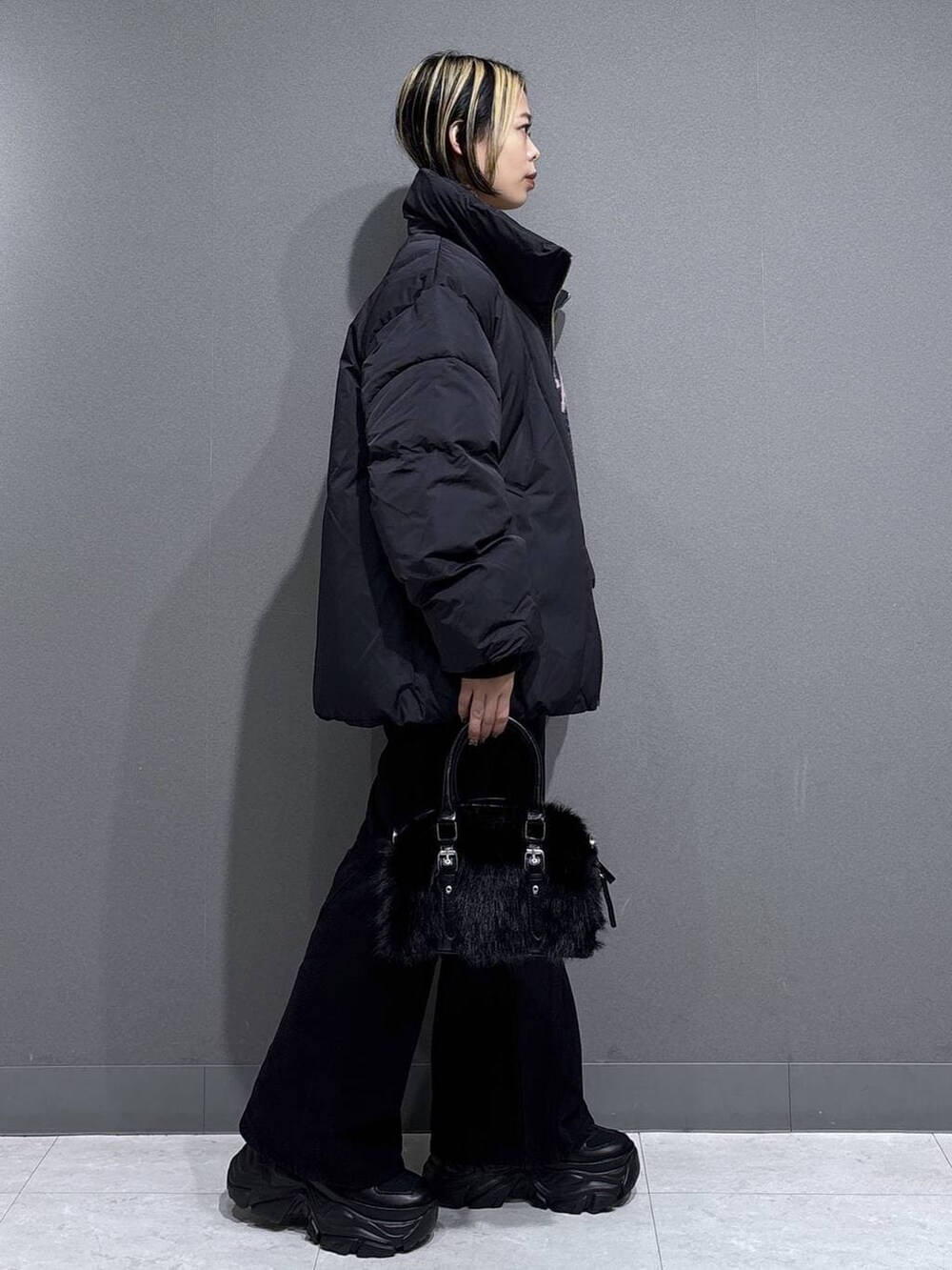 ブラック系のブーツ、ブラック系のデニムパンツ、ブラック系のブルゾンを着用したレディースの冬コーディネートの3枚目の写真