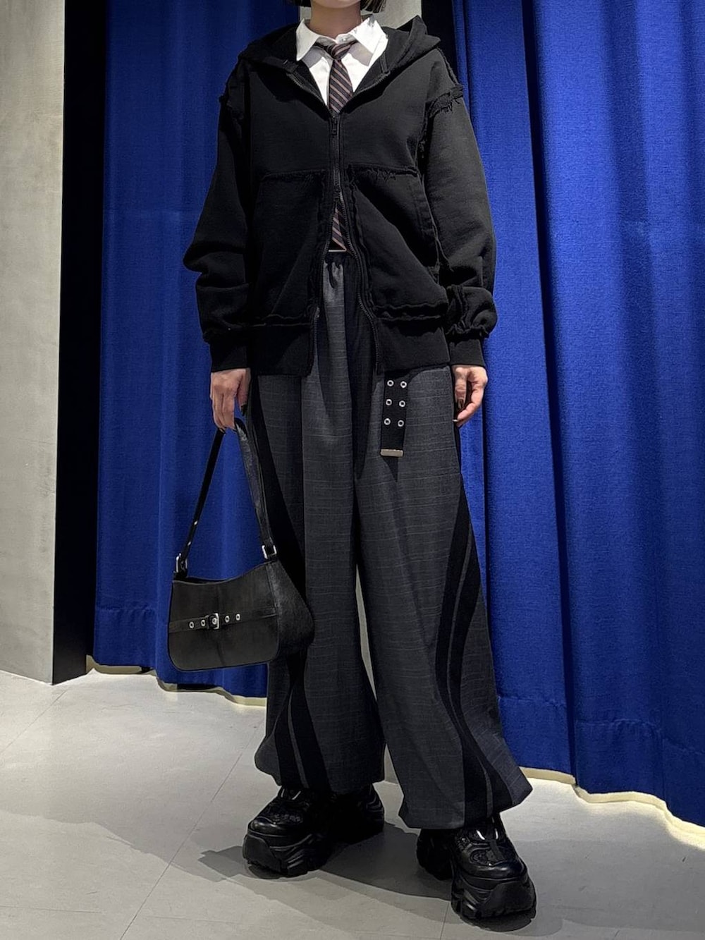 ブラック系のスニーカー、グレー系のその他パンツ、ホワイト系のシャツ/ブラウスを着用したレディースの春コーディネートの2枚目の写真