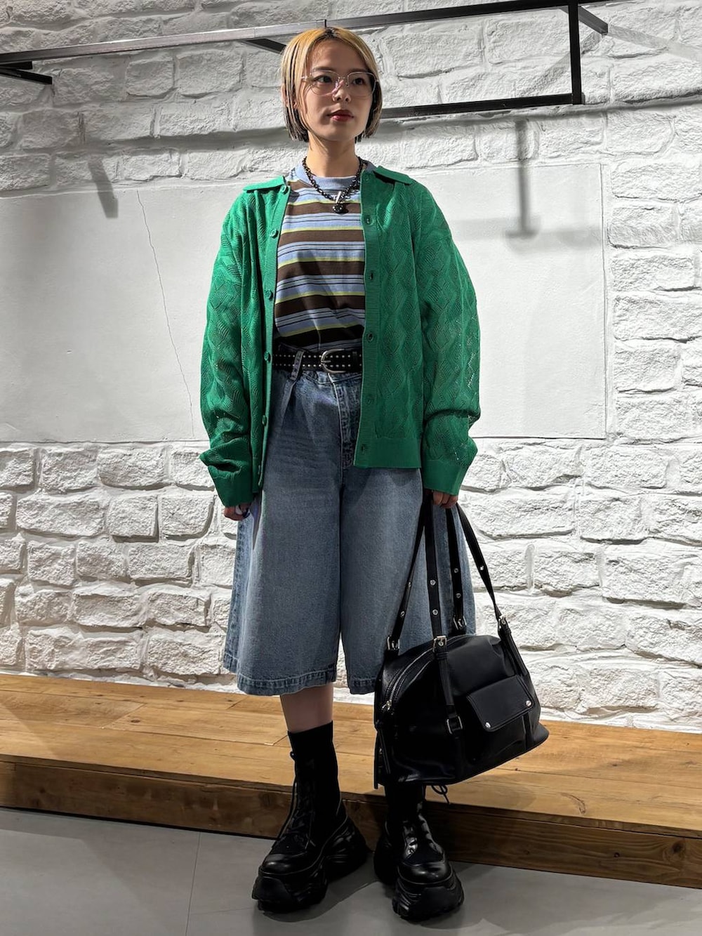 ブラック系のブーツ、ブルー系のデニムパンツ、ブラウン系のTシャツ/カットソーを着用したレディースの春コーディネートの2枚目の写真