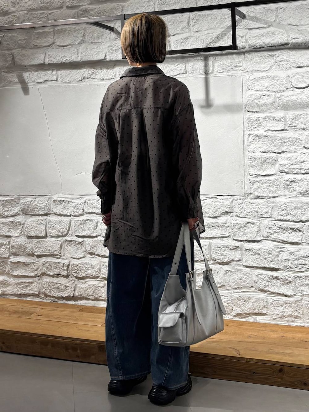 ブラック系のキャミソール、ブルー系のデニムパンツ、ブラック系のサンダルを着用したレディースの春コーディネートの5枚目の写真