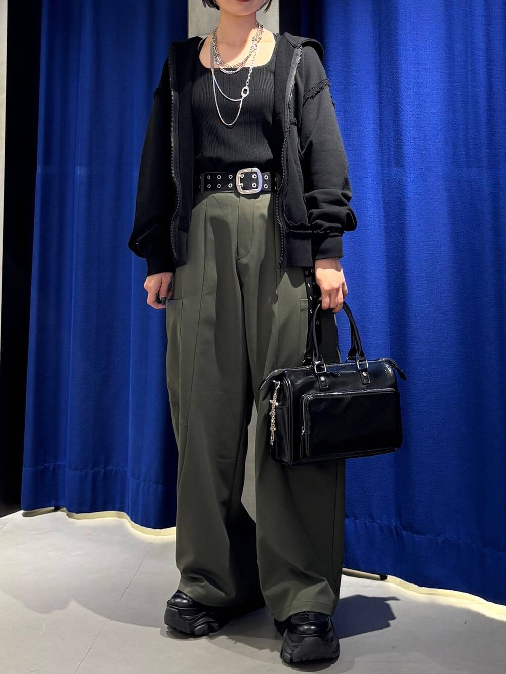 ブラック系のショルダーバッグ、ブラック系のタンクトップ、グリーン系のカーゴパンツを着用したレディースの春コーディネートの4枚目の写真