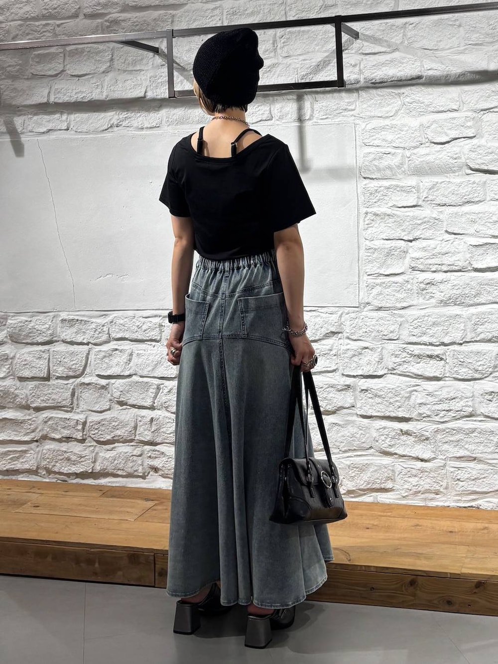 ブラック系のTシャツ/カットソー、ブルー系のデニムスカート、ブラック系のショルダーバッグを着用したレディースの夏コーディネートの6枚目の写真
