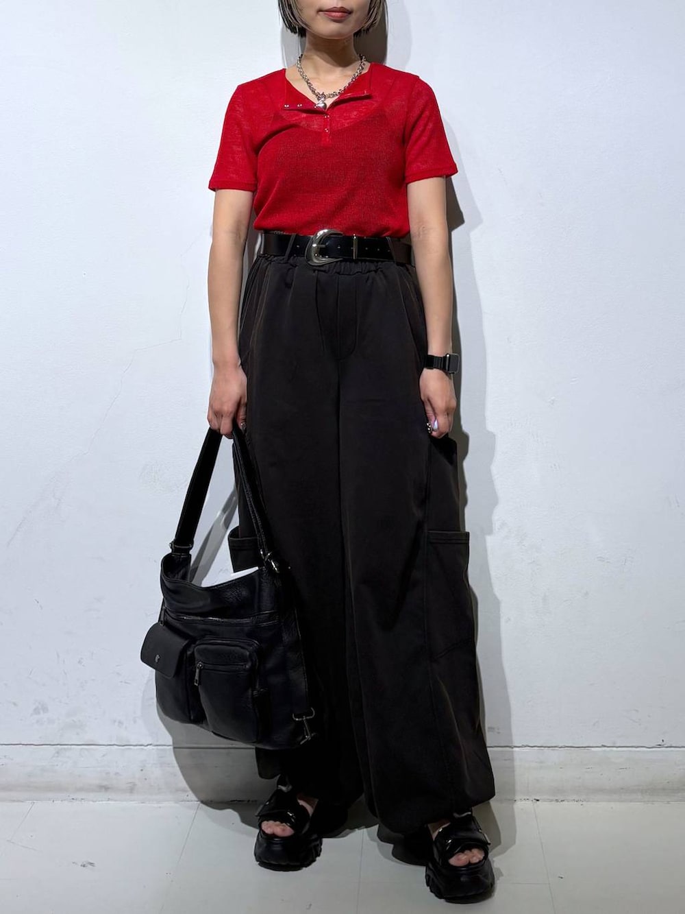 ブラック系のショルダーバッグ、ブラック系のサンダル、レッド系のTシャツ/カットソーを着用したレディースの春コーディネートの3枚目の写真