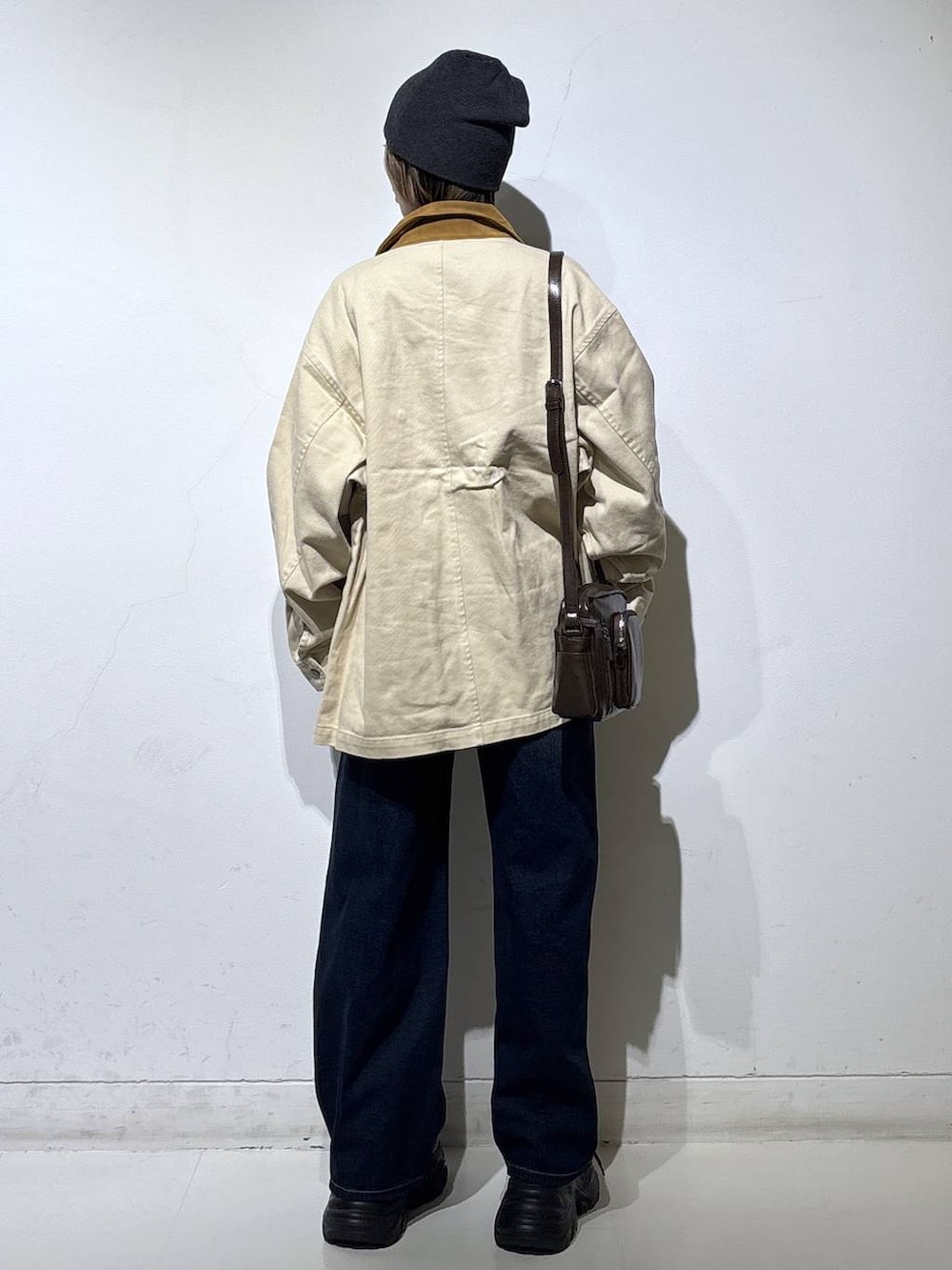 ブラック系のスニーカー、ブルー系のスラックス、ブラウン系のショルダーバッグを着用したレディースの春コーディネートの5枚目の写真