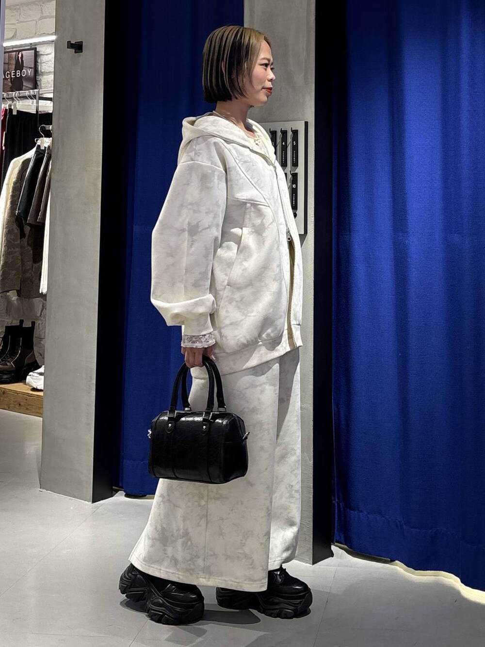 ブラック系のブーツ、ホワイト系のTシャツ/カットソー、ホワイト系のスカートを着用したレディースの冬コーディネートの5枚目の写真