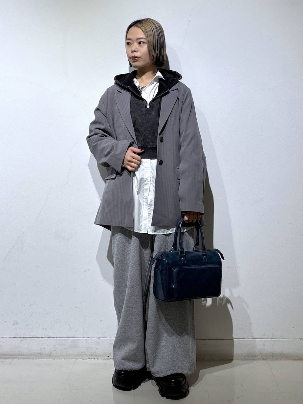 ブラック系のスニーカー、グレー系のテーラードジャケット、グレー系のパーカーを着用したレディースの冬コーディネートの3枚目の写真