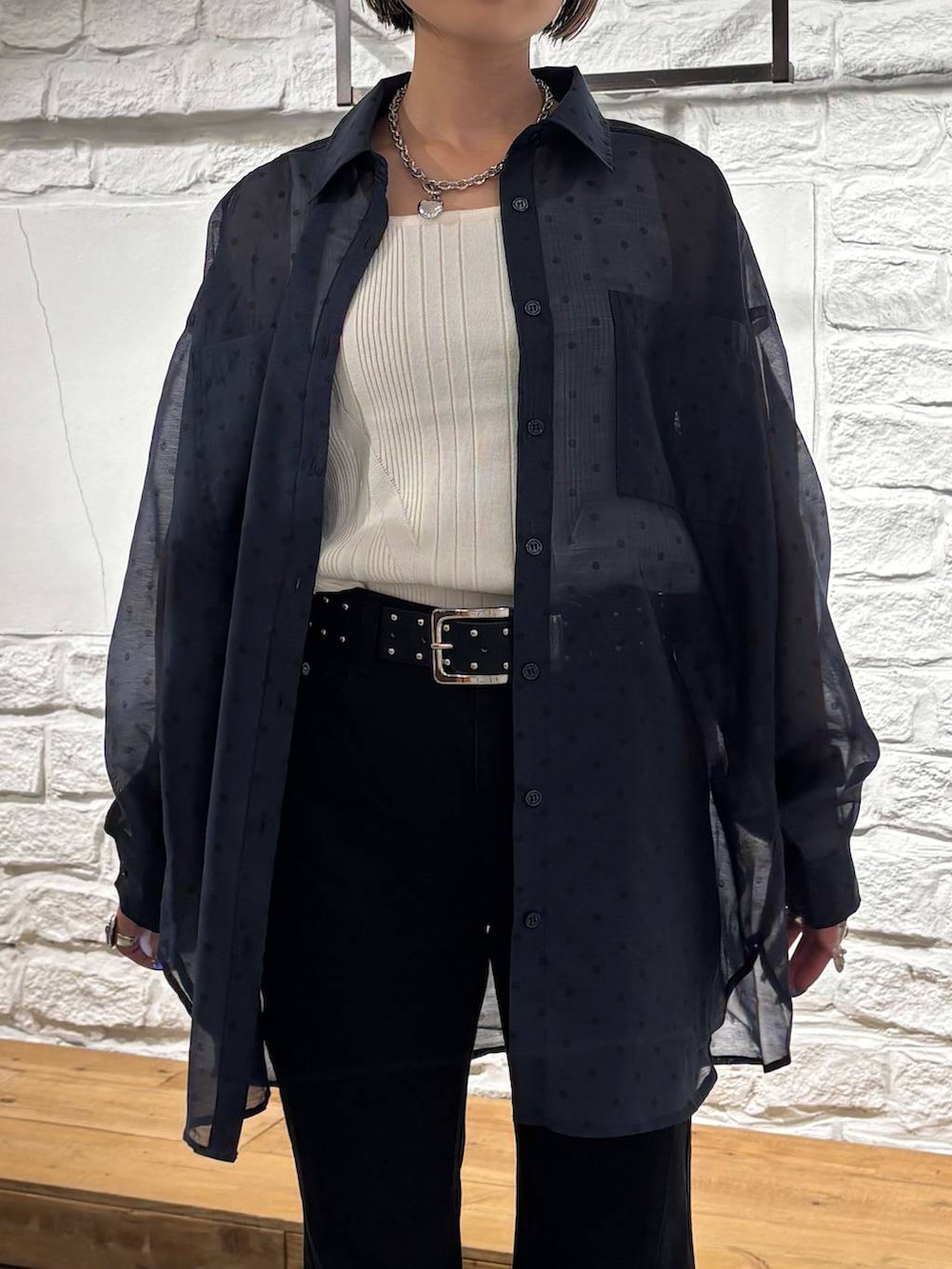 ブラック系のデニムパンツ、ホワイト系のタンクトップ、ブラック系のショルダーバッグを着用したレディースの夏コーディネートの3枚目の写真