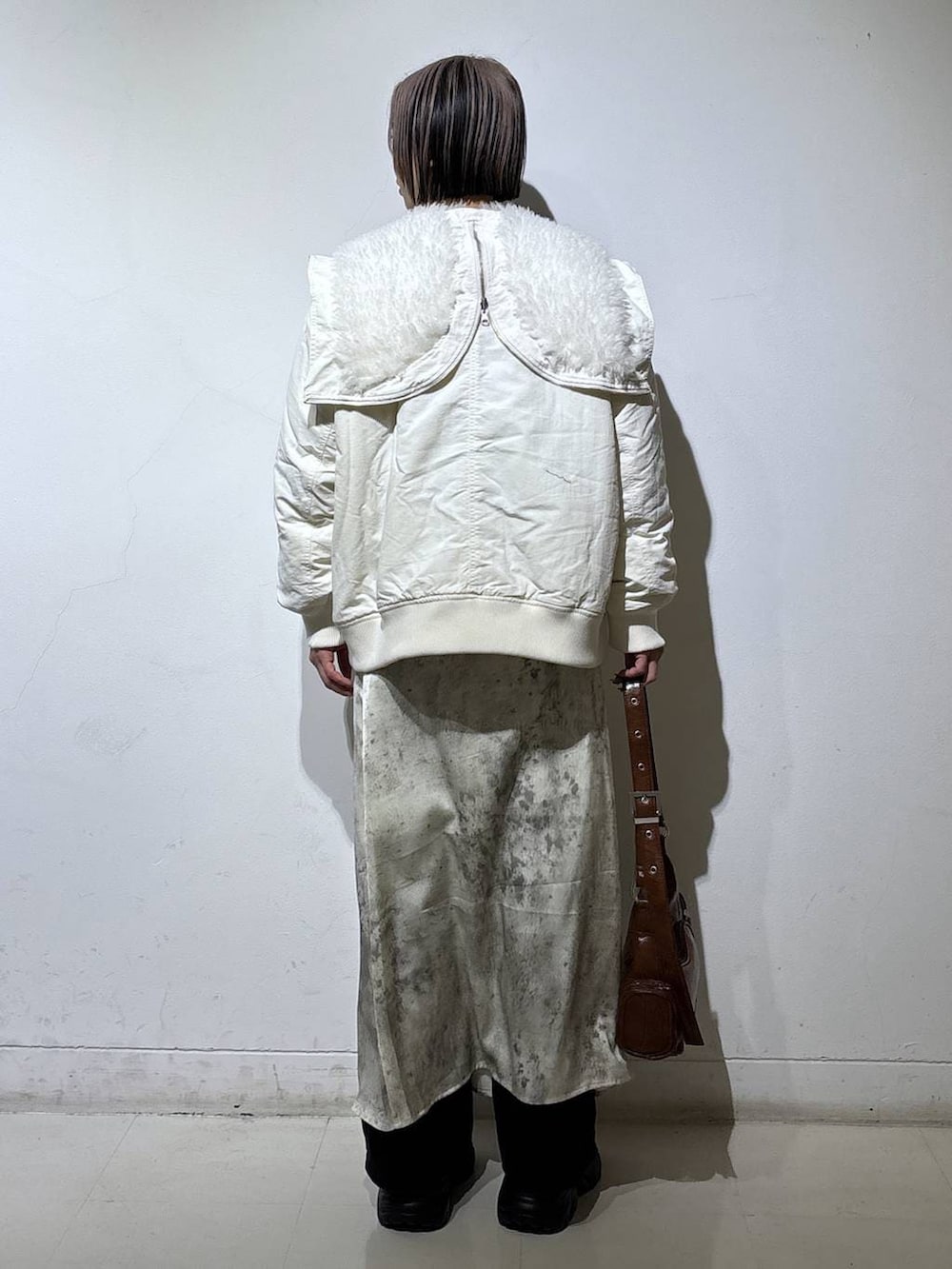 ブラック系のブーツ、ホワイト系のブルゾン、ブラウン系のショルダーバッグを着用したレディースの冬コーディネートの4枚目の写真