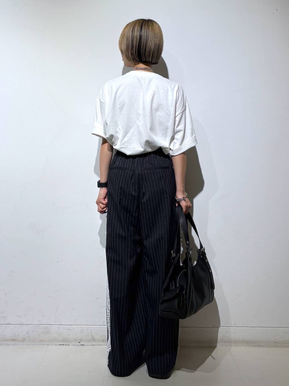 ブラック系のサンダル、ホワイト系のTシャツ/カットソー、ブルー系のスラックスを着用したレディースの夏コーディネートの5枚目の写真