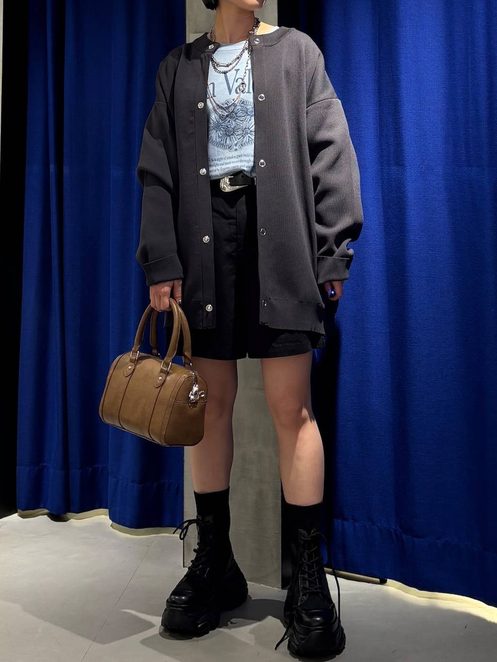 ブラック系のブーツ、ブラウン系のボストンバッグ、ブラック系のその他パンツを着用したレディースの春コーディネートの3枚目の写真