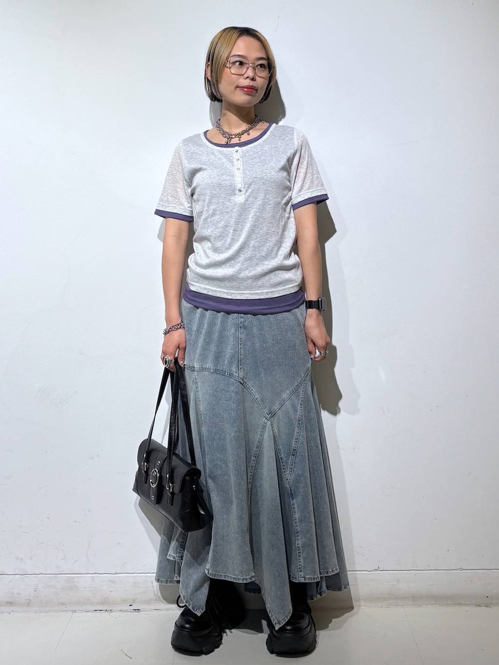 ブラック系のブーツ、ブルー系のデニムスカート、グレー系のTシャツ/カットソーを着用したレディースの夏コーディネートの2枚目の写真