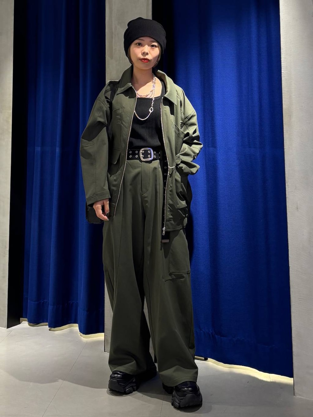 ブラック系のスニーカー、ブラック系のタンクトップ、グリーン系のカーゴパンツを着用したレディースの春コーディネートの2枚目の写真