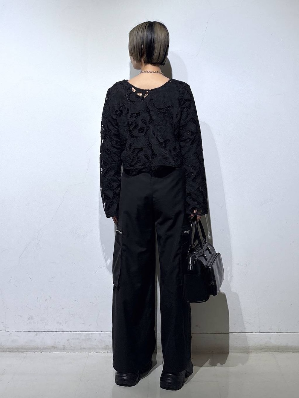 ブラック系のスニーカー、ブラック系のキャミソール、ブラック系のショルダーバッグを着用したレディースの春コーディネートの4枚目の写真