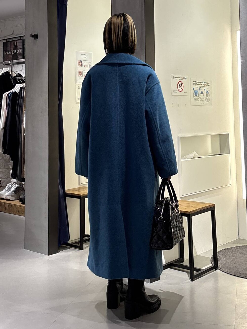 グリーン系のチェスターコート、ブラック系のブーツ、ブラック系のその他パンツを着用したレディースの冬コーディネートの4枚目の写真