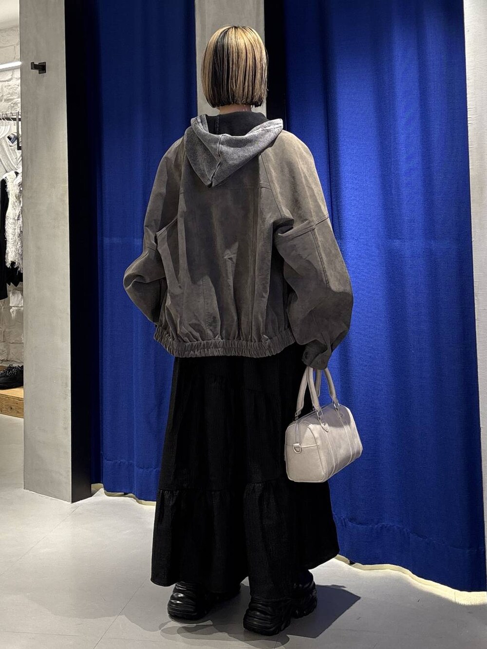 ブラック系のスニーカー、ホワイト系のボストンバッグ、グレー系のパーカーを着用したレディースの冬コーディネートの5枚目の写真