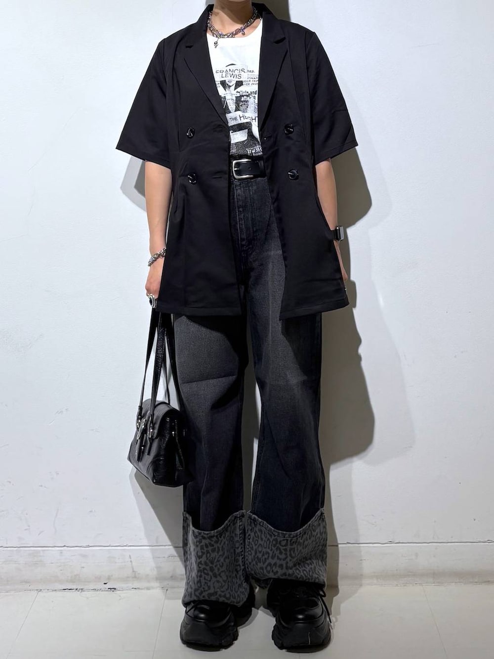 ホワイト系のTシャツ/カットソー、ブラック系のスニーカー、ブラック系のデニムパンツを着用したレディースの夏コーディネートの3枚目の写真