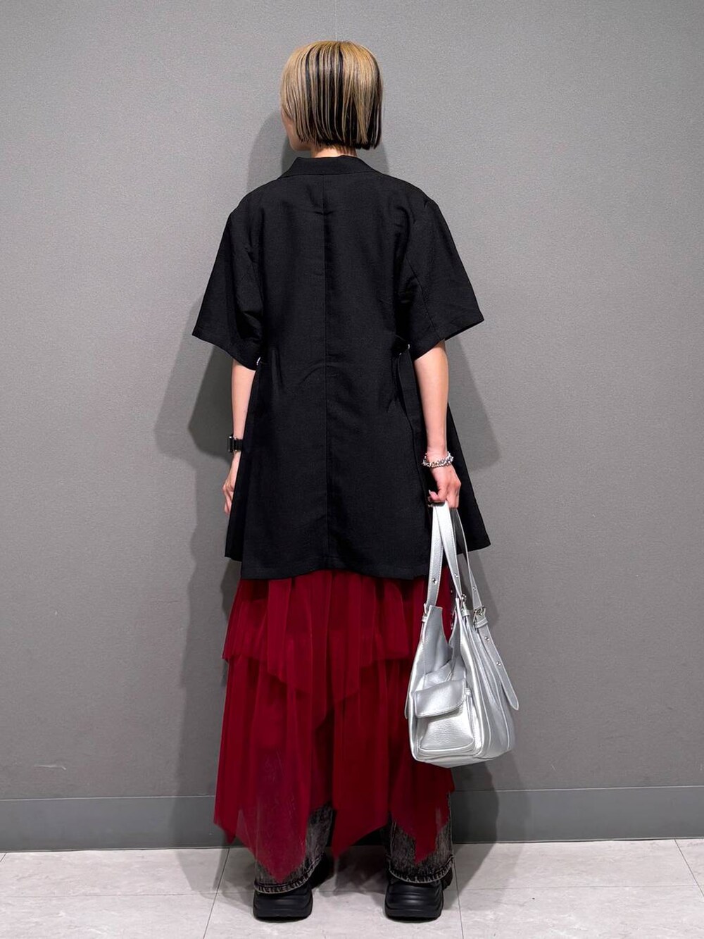 ブラック系のスニーカー、ブラック系のデニムパンツ、ホワイト系のTシャツ/カットソーを着用したレディースの春コーディネートの5枚目の写真