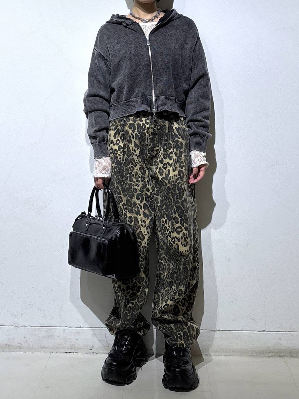 ブラック系のスニーカー、ホワイト系のTシャツ/カットソー、ブラウン系のデニムパンツを着用したレディースの冬コーディネートの2枚目の写真