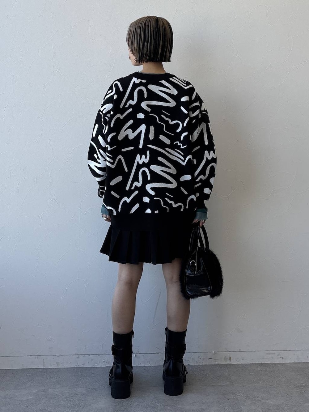 ブラック系のブーツ、ブラック系のボストンバッグ、ブラック系のその他パンツを着用したレディースの冬コーディネートの7枚目の写真