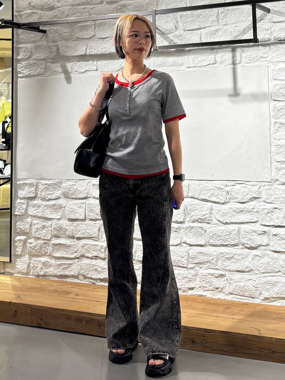 ブラック系のデニムパンツ、ブラック系のサンダル、ブラック系のハンドバッグを着用したレディースの春コーディネートの2枚目の写真