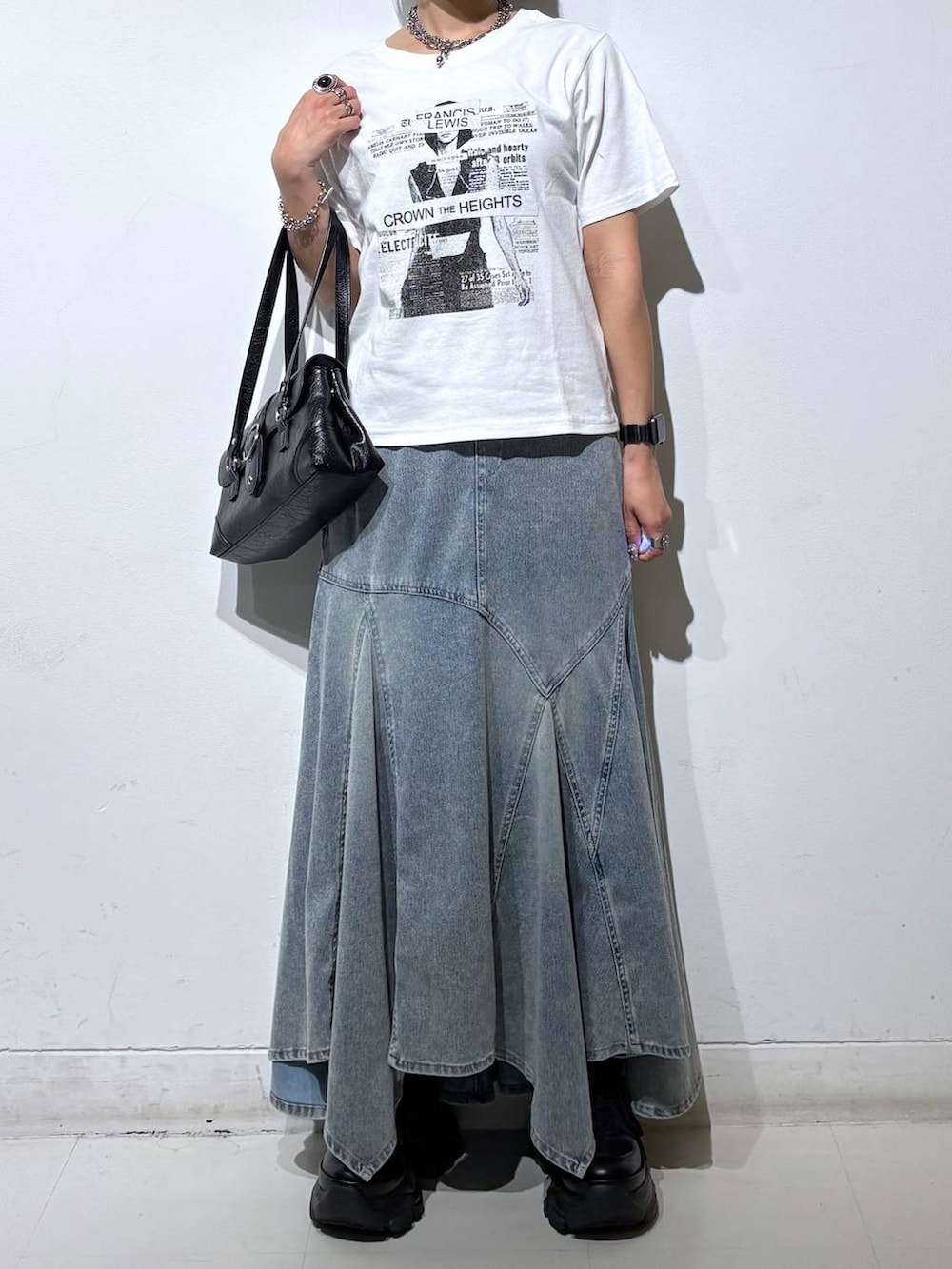 ホワイト系のTシャツ/カットソー、ブラック系のスニーカー、ブルー系のデニムスカートを着用したレディースの夏コーディネートの3枚目の写真