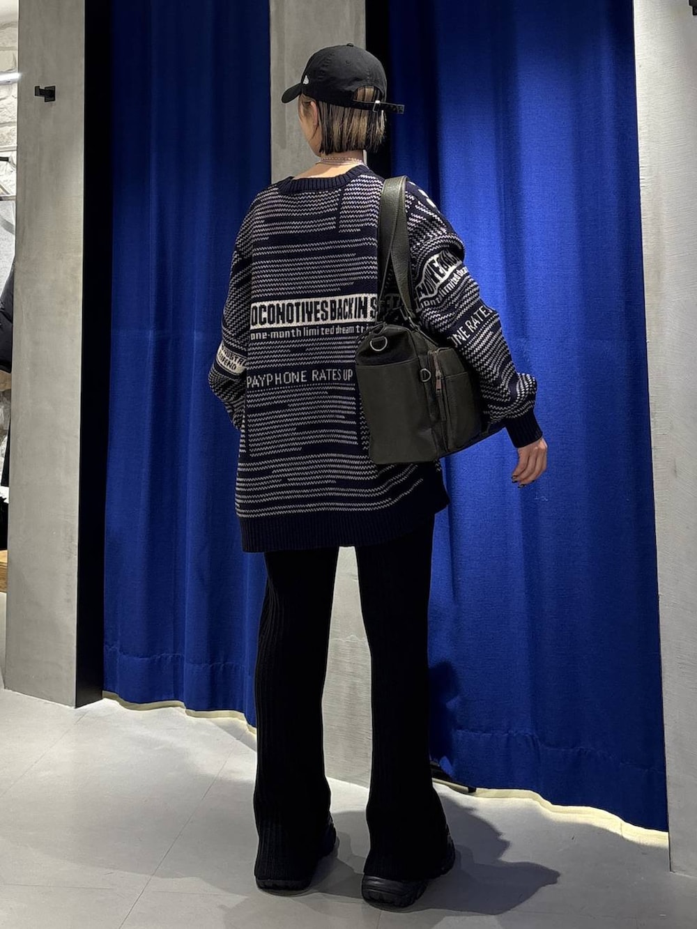 ブラック系のブーツ、グリーン系のボストンバッグ、ブラック系のその他パンツを着用したレディースの冬コーディネートの4枚目の写真