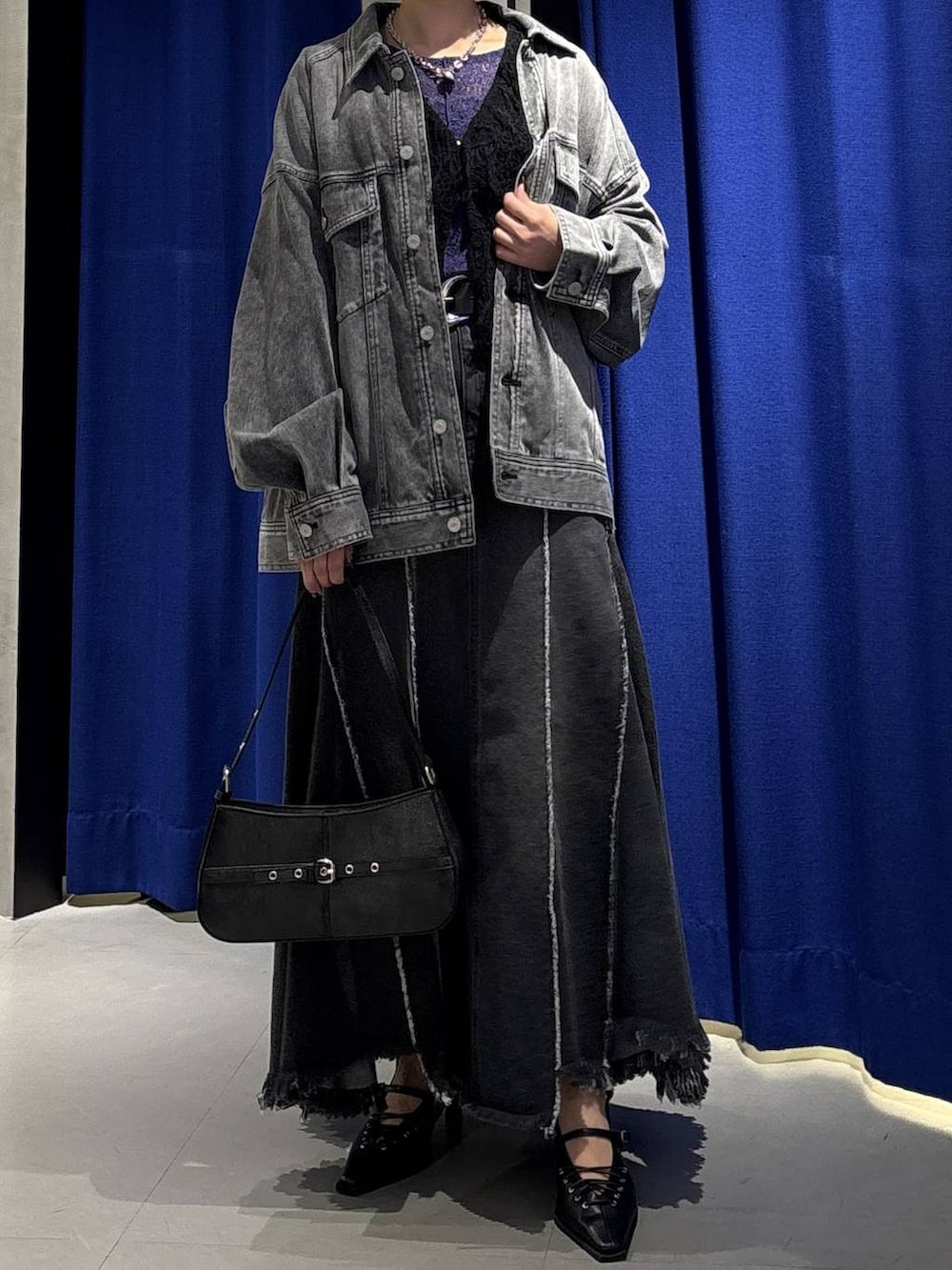 ブラック系のハンドバッグ、ブラック系のブルゾン、ブラック系のサンダルを着用したレディースの春コーディネートの2枚目の写真