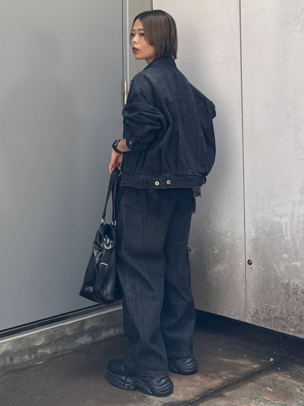 ブラック系のボストンバッグ、ブラック系のデニムパンツ、ブラック系のデニムジャケットを着用したレディースの夏コーディネートの6枚目の写真